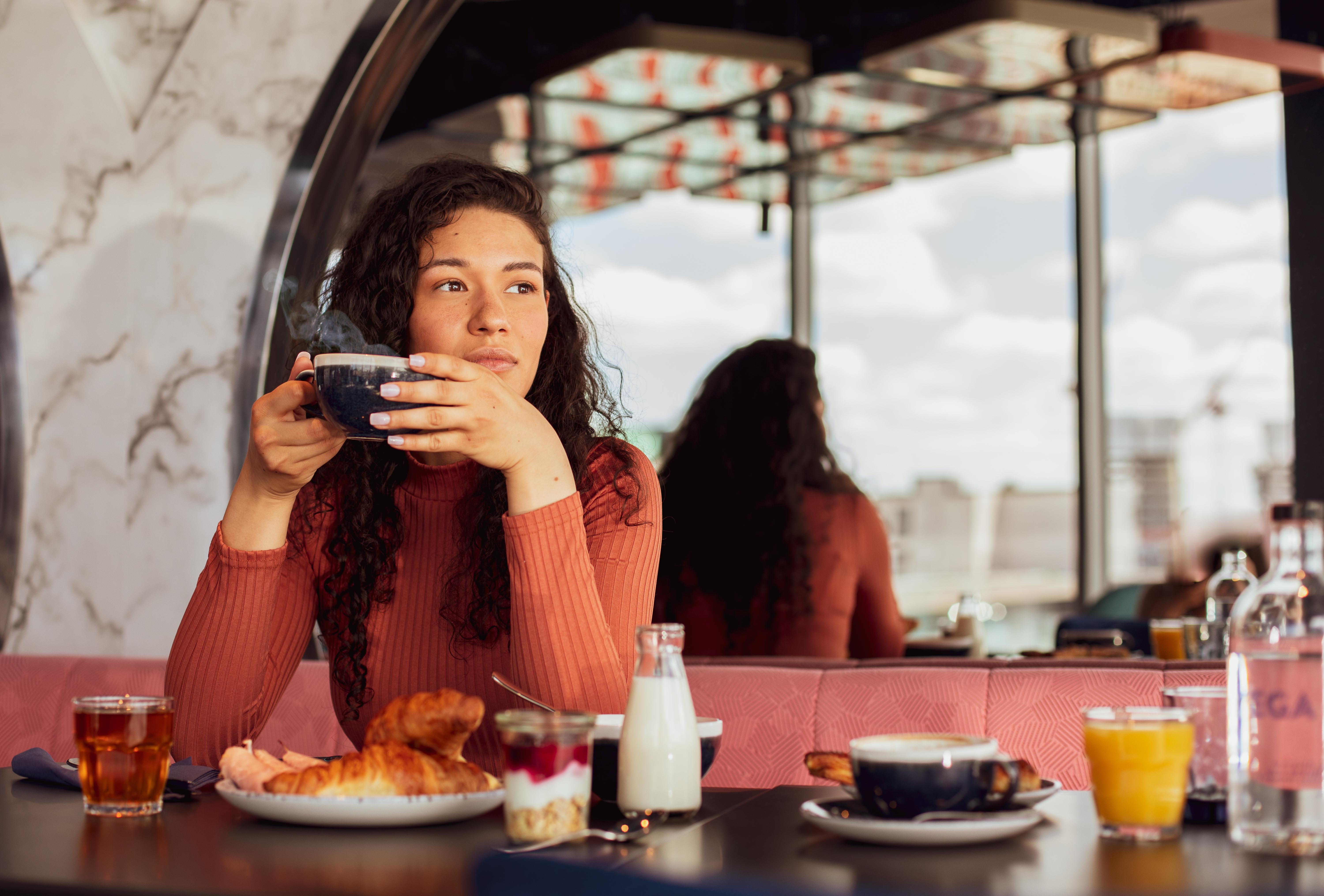 Yotel Glasgow Ngoại thất bức ảnh A woman having breakfast at a cafe.